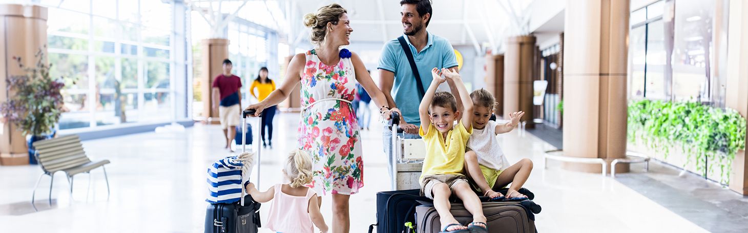 Parents with two children and suitcases at the train station
