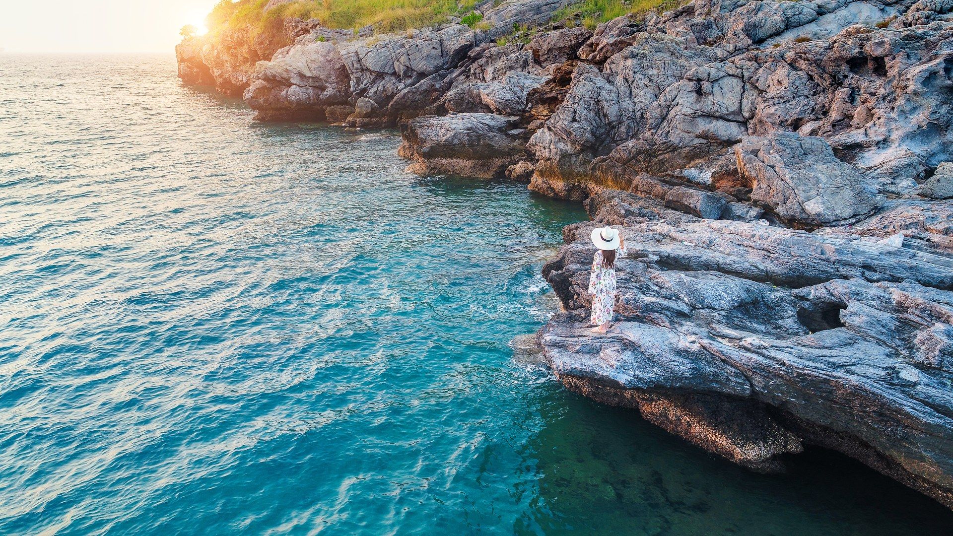 Sunset over the Croatian Adriatic Silhouette of a person standing on a rocky Croatian shore, watching the sunset over the Adriatic